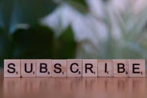 The word subscribe written with Scrabble tiles
